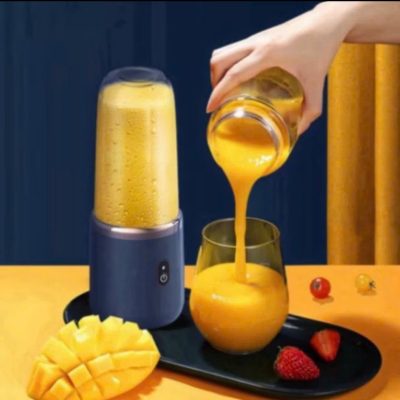 a hand pouring orange juice into a glass